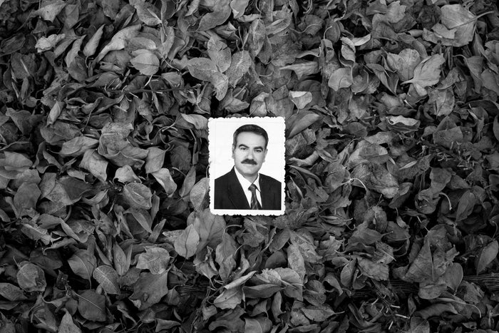 A photograph of Sadiq's father's portrait resting among dried leaves.