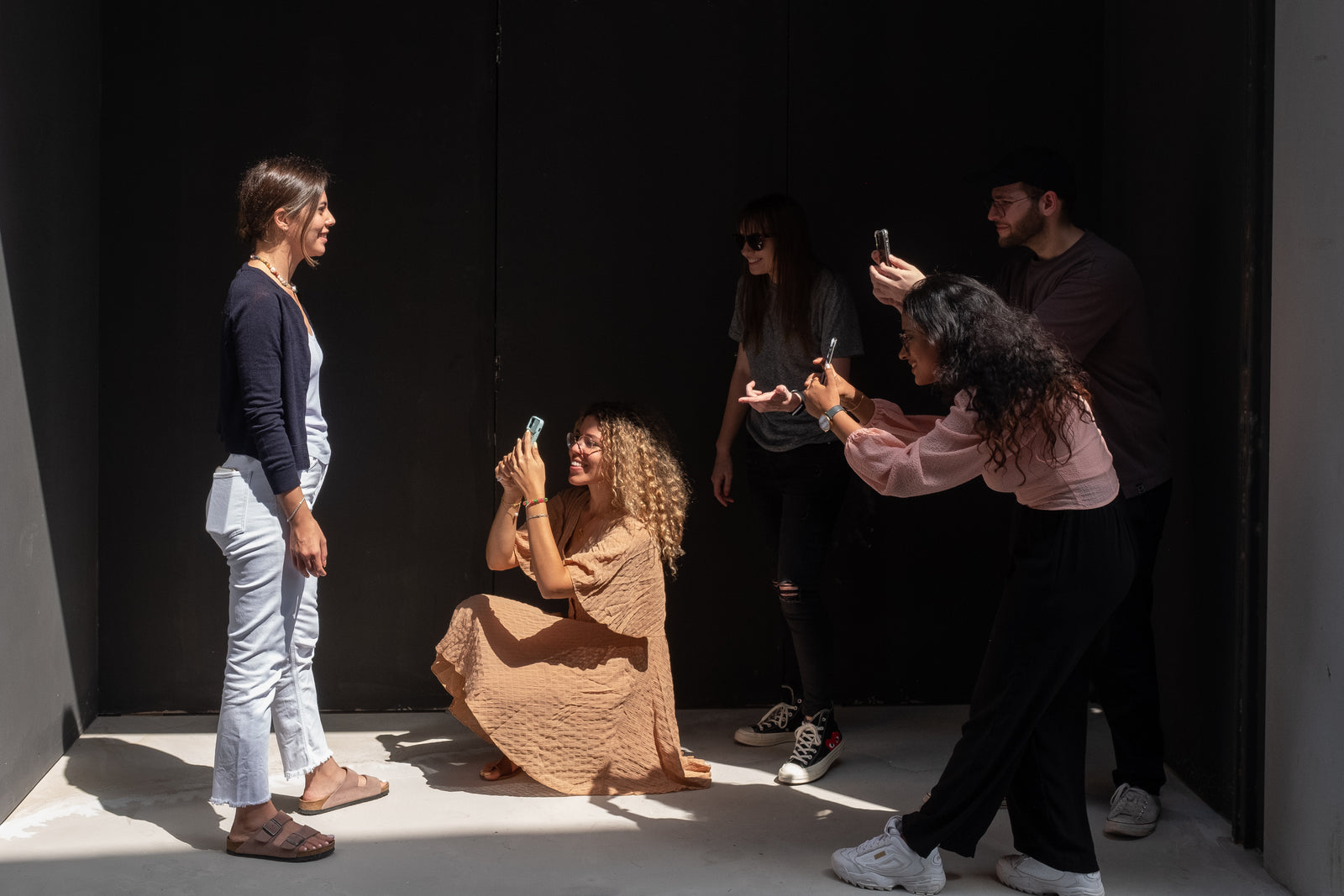 Workshop participants photographing a model in dramatic side lighting during the GPP smartphone photography class