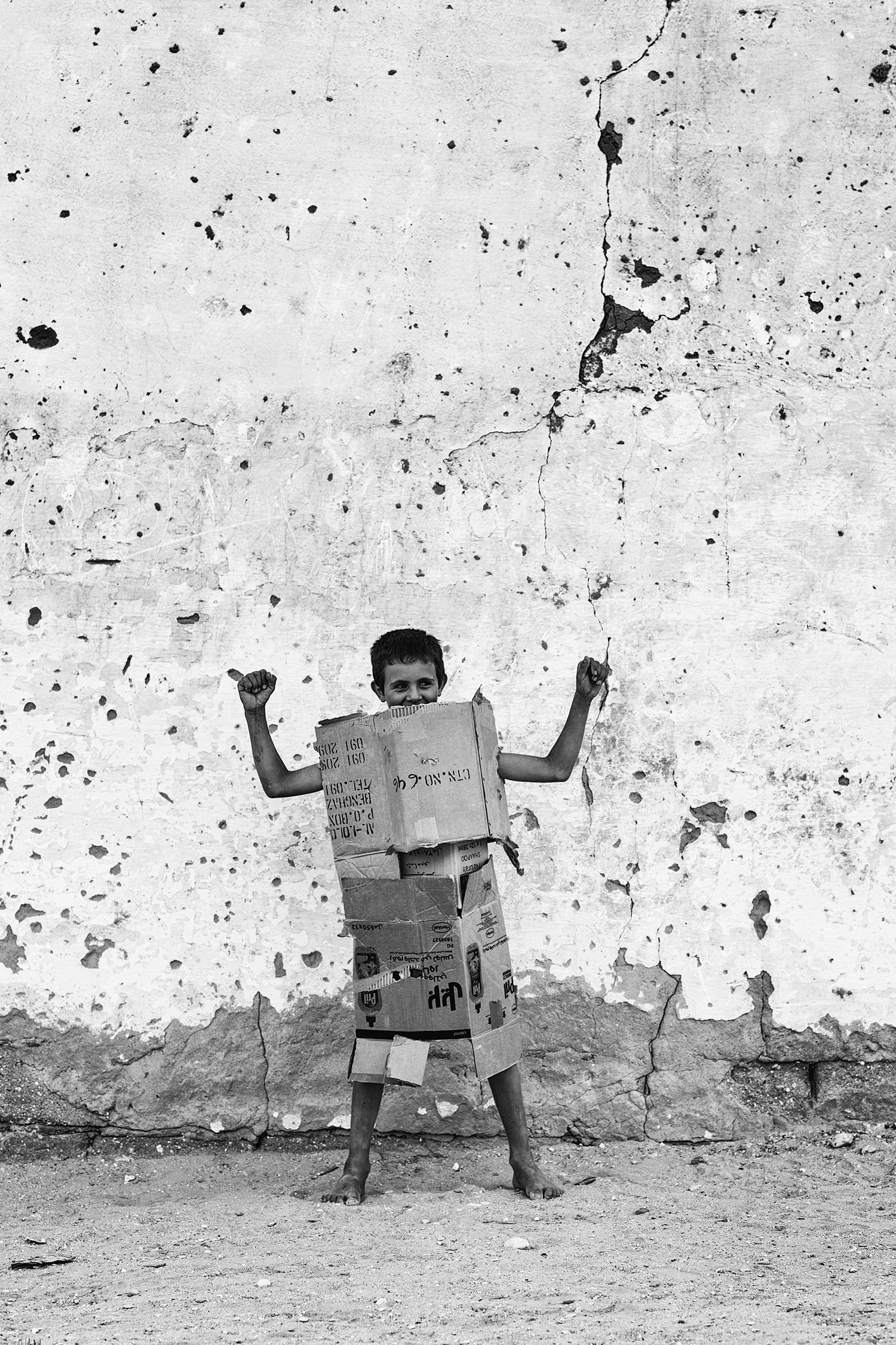 A boy, playing with cardboard armor.