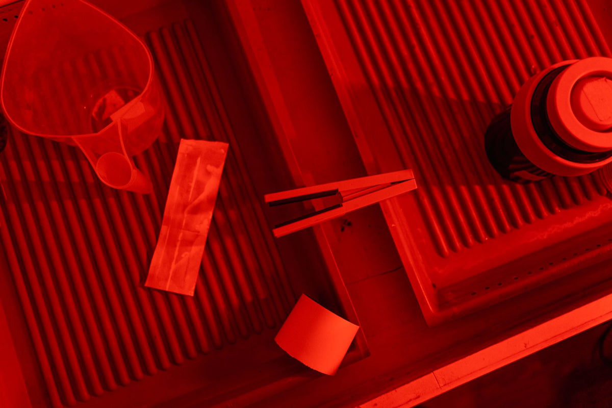 Developing trays under a red safelight in a darkroom