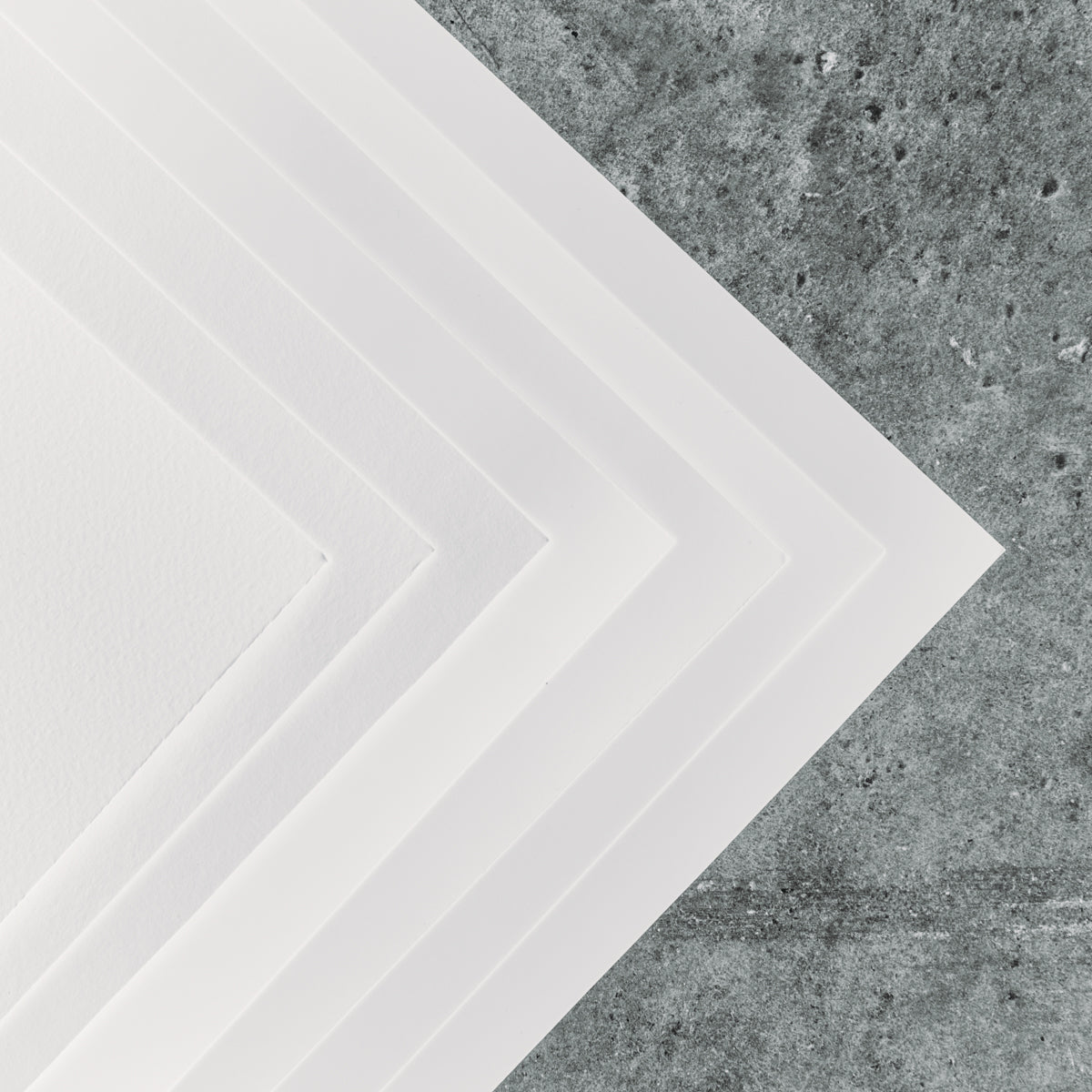 Fine-art papers stacked on concrete